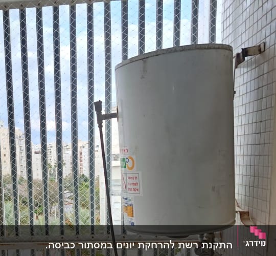 רשת יונים מותקנת על חלון עם דוד שמש
